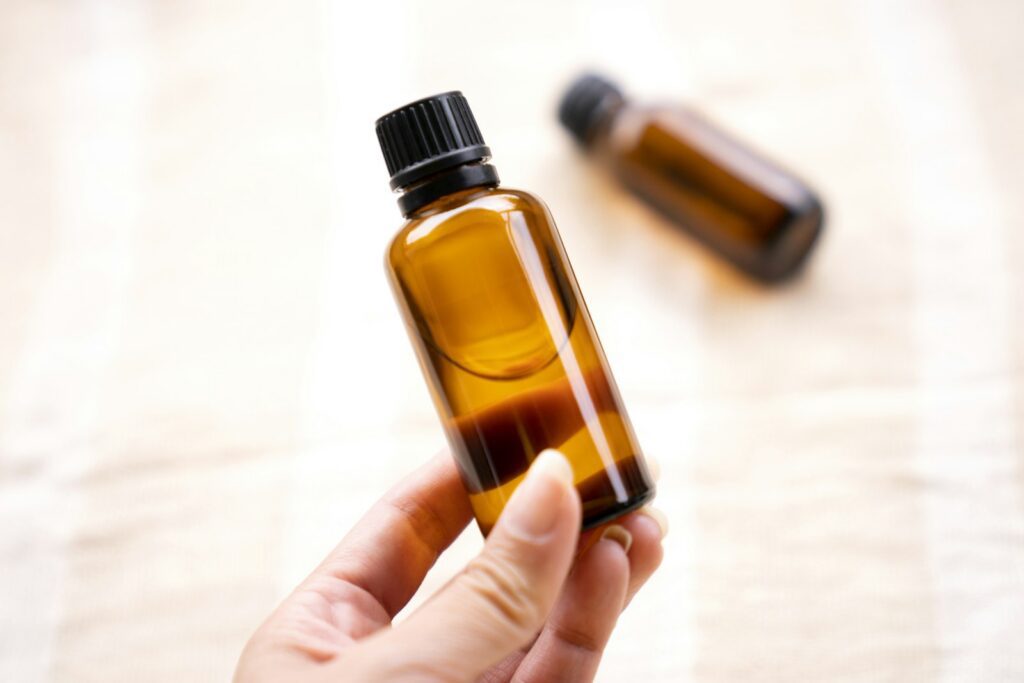 Amber attar and perfume oil bottles held in hand