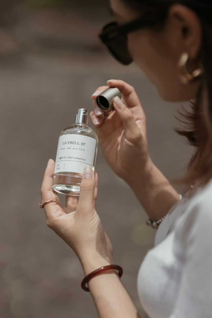 Woman holding a bottle of perfume, illustrating how to properly wear and apply fragrance