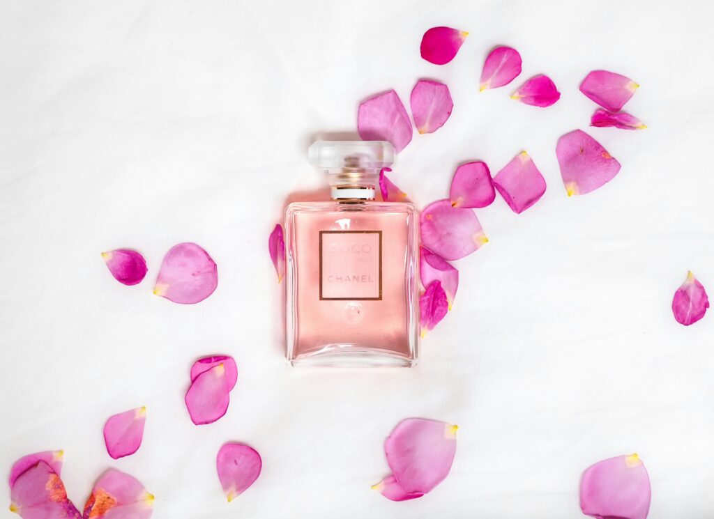 Perfume bottle styled with pink flower petals, gift-worthy presentation